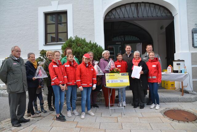 Bez. Rettungskommandant Anton Schilcher (links) mit Kindern des Jugend-Rotkreuzes und den Damen des 2nd Hand Shops: Frohmut Tippler, Christl Weidinger, Maria Sampl, Hermine Bliem, Sabine Pfeifenberger und Andrea Schlick (v. links); RE: JRK-Koordinator Manfred Kessler und Vzbgm Roland Holitzky Beim 2nd Hand Shop-Team nicht im Bild: Margit Graggaber