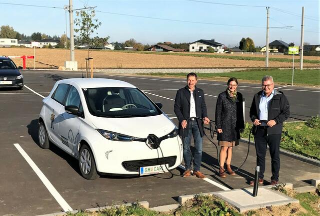 Bürgermeister Ingo Dörflinger, Bettina Feischl (Bürgerservice) und  Umweltausschuss-Obmann Anton Pühringer mit dem "E-Carli" am Standort der geplanten neuen E-Tankstelle am P+R-Parkplatz.   | Foto: Gde. Kirchham/Krojo