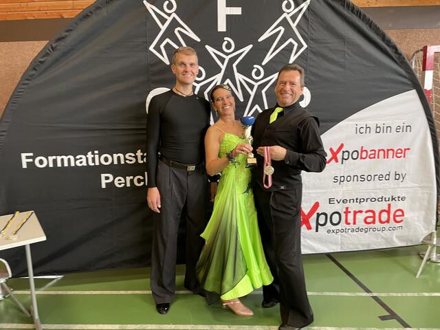 Alexandra und Andreas Christian Salusek (r.) mit ihrem Tanztrainer Andreas Schogger und einigen ihrer Auszeichnungen.