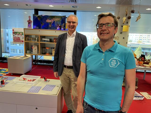 Bibliotheksleiter Helmut Windinger und Peter Eder von der Spürnasen GmbH bei der Spürnasenecke in der Stadtbibliothek.