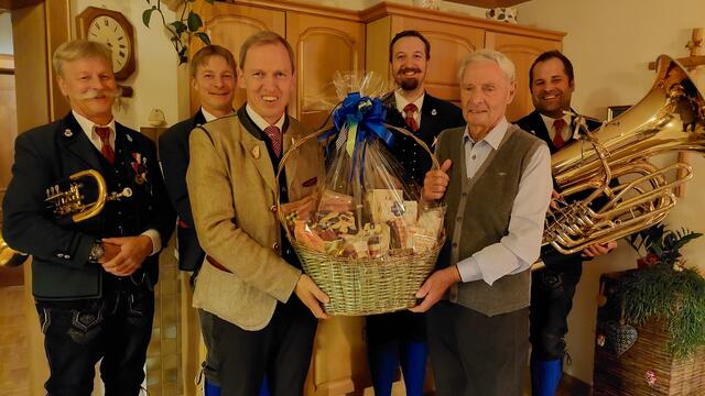 Geburstags-"Kind" Rupert Schiefer mit Bgm. Thomas Oberreiter und Musikanten der TMK Flachau. | Foto: Gde. Flachau