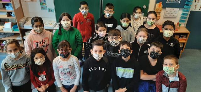 Stolz präsentieren die Schülerinnen und Schüler der 4c ihre selbst genähten Masken.