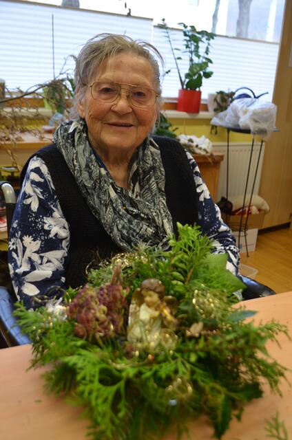 Bewohnerin Elfriede Rieger holt sich mit dem Gesteck weihnachtliche Stimmung in ihr Zimmer.