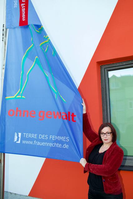 Gerlinde Metzger bei der Fahne vor der AKNÖ Neunkirchen.
