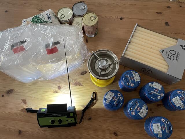 Ein Notfallpaket ist schnell geschnürt: Gaskartuschen für den Kocher, Dosen- und Haltbarnahrung, Wasser und Kurbelradio samt Taschenlampe.