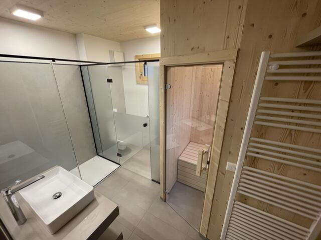 Das großügige Bad ist mit eigener Sauna ausgestattet.