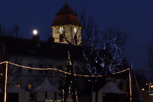 Ein malerisches Bild ergeben die Lichterketten an den Bäumen mit der dahinterliegenden Altsimmeringer Pfarrkirche und dem strahlenden Mond.