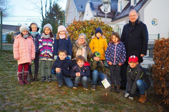 Freuen sich über die neu gepflanzten Bäume: Bürgermeisterin Ulrike Kitzinger, Direktor Dieter Komanovits und einige Kinder Volksschule Sigleß