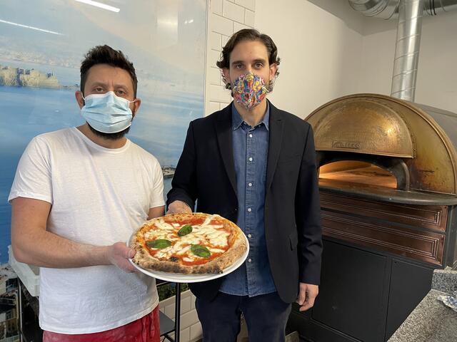 Gaetano Brancato (r) und sein Partner Pietro Andolfi mit ihrer neapolitanischen Pizza. Im Hintergrund ein Pizza-Ofen aus Neapel.