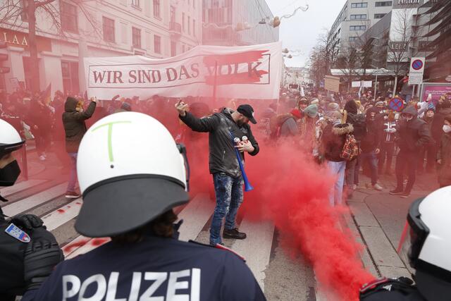 Ein Demonstrant setzt sich in Szene, eine Gruppe hantiert mit Pyrotechnik. Die Polizei reagiert mit Pfefferspray. | Foto: APA Picturedesk