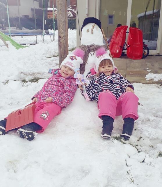 Sina und Stella Posch genießen nach dem Schneemannbauen sichtlich ihr Plätzchen im Schnee.  | Foto: Manuela P. 