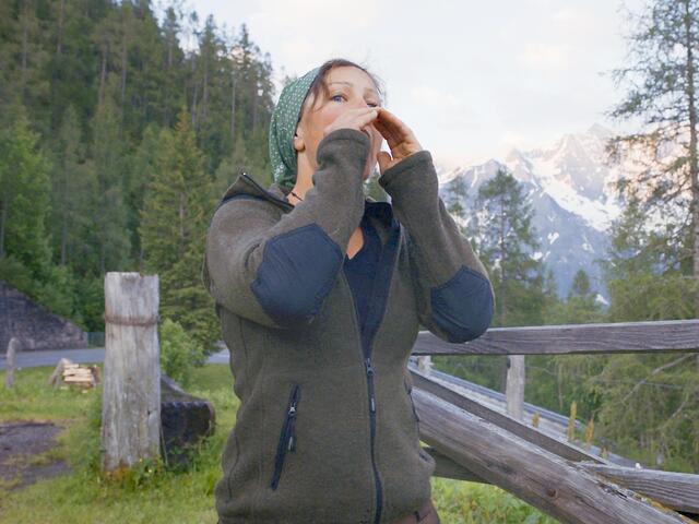 Frühmorgens auf der Piffalm ruft Sennerin Martina Mühlbauer ihre Kühe herbei…