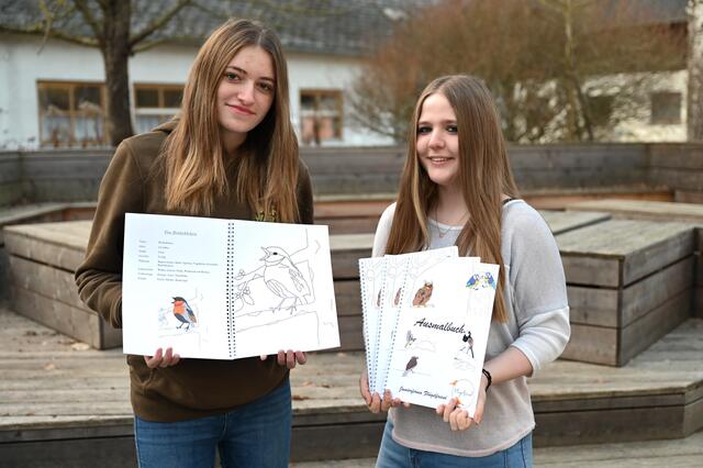 (v.l.n.r.) Die Schülerinnen Katharina Eder und Nadine Zöchling präsentieren die Malbücher. | Foto: Jürgen Mück
