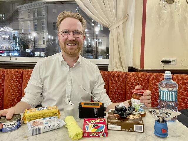 Kekse, Konserven, Mineralwasser, Feuchttücher, Gaskocher und ein Kartenspiel – Markus Unterauer mit seinen Notfall-Utensilien. | Foto: Baumgartner/BRS