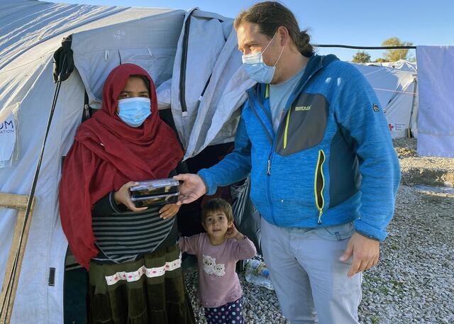 Pascal Violo übergibt Boxen mit Essen an eine Mutter. Hier in Griechenland. | Foto: Karawane der Menschlichkeit
