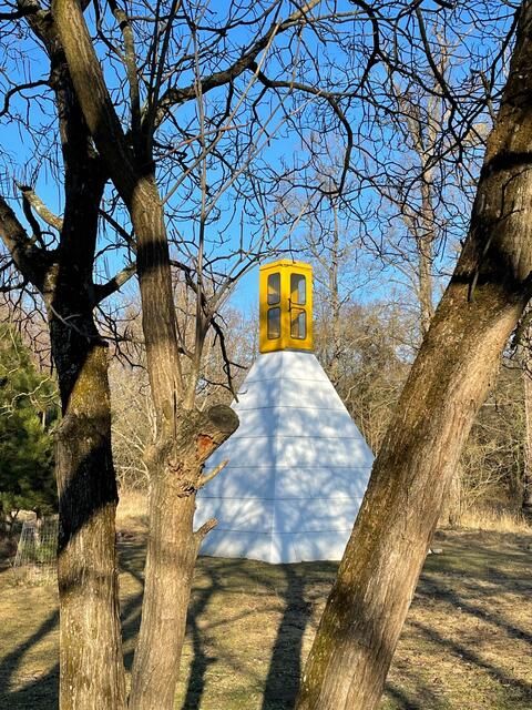 Eine gelbe Telefonzelle auf einer weißen Pyramide in einem Schlosspark von Andras Galik und Balint Havas | Foto: Necker