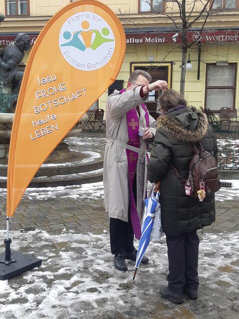 Vor dem Café Wortner wird zum vierten Mal das "Aschenkreuz to go" erteilt.  | Foto: Pfarre zur Frohen Botschaft, Regina Tischberger &amp; Stefan Wallisch
