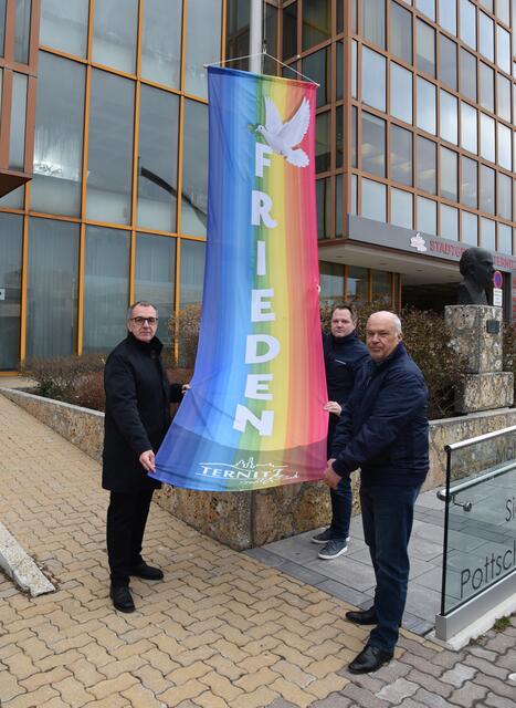 Bürgermeister Rupert Dworak, Stadtvize Christian Samwald und Sozialstadtrat Franz Stix hissen – als Friedenszeichen – die Regenbogenfahne beim Rathaus. | Foto: Stadtgemeinde Ternitz