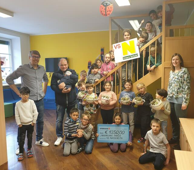 Direktor Thomas Köhle, Lehrerin Germana Pfennig und die Kinder der 1. Klasse freuen sich über € 1350,00 an Spendengeldern und übergeben Maximilians Vater dieses ganz besondere Ostergeschenk.