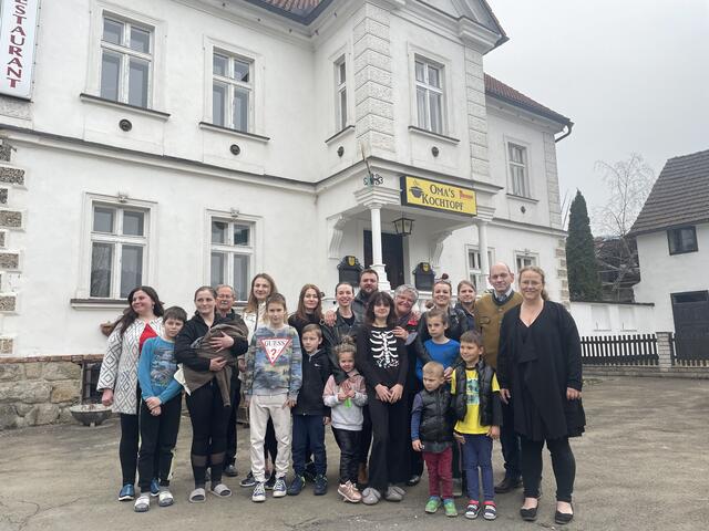 Die 15 Flüchtlinge aus der Ukraine vor ihrem vorläufigen neuen Zuhause in St. Barbara-Mitterdorf mit Helfern und den Hausbesitzern.  | Foto: Koidl