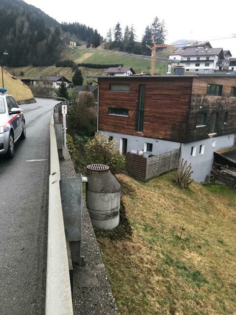 Der Deckel dieses Schachtes in Axams/Bachl wurde über das abschüssige Feld gerollt und landete im Garten einen Hauses. | Foto: Polizei Axams