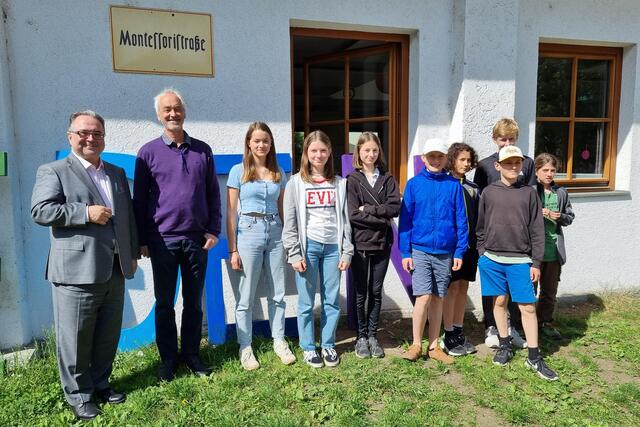 V.l.n.r.: Der evangelische Bischof Michael Chalupka, Montessori-Schulleiter Gernot Candolini und Schüler der Montessori-Schule | Foto: epd/Dasek