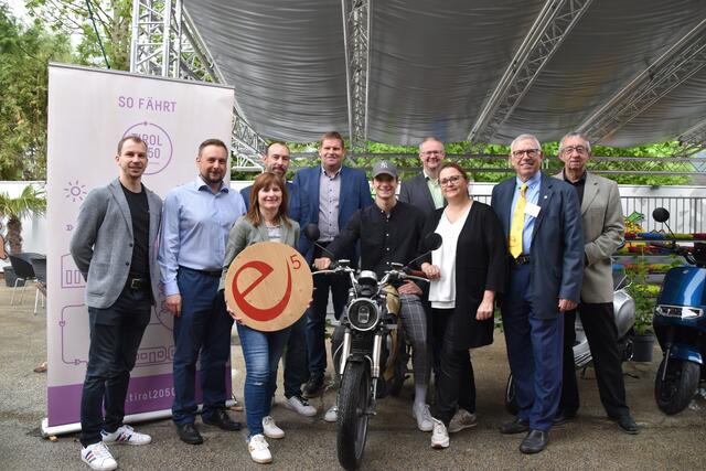 Thomas Geisler (Energie Tirol), Stefan Steinlechner (e5-Team Wörgl), Anni Häusler (e5-Teamleiterin Kundl), Reiner Unger (KEM-Manager Alpbachtal), Martin Gschwentner (Vizebürgermeister Schwoich), Noah Lambauer (E-Moped Besitzer), Josef Auer (Bürgermeister Breitenbach), Iris Kahn (Umweltreferentin Wörgl), Franz Hörmann (e5-Teamleiter Kirchbichl) und Karl Schweitzer (e5-Teamleiter Angerberg) (v.l.) freuen sich. | Foto: Barbara Fluckinger