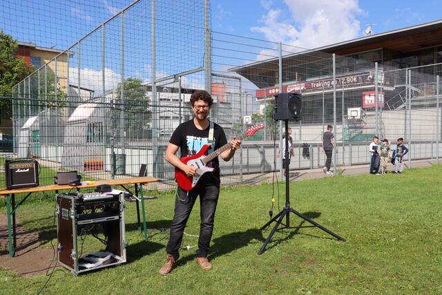 Lehrer Sebastian Beer stimmte das Friedenslied mit seiner Gitarre an. | Foto: Christoph Klausner