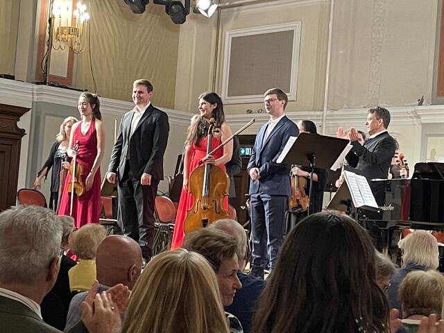 Das Badener Klaviertrio mit dem Komponisten (r.) und dem applaudierenden Dirigenten nach der Welturaufführung