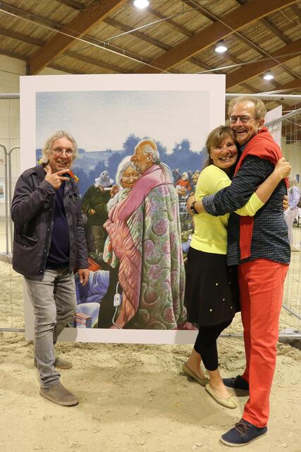Gerhard Haderer mit Ulrike und Josef Leitner, die eine Reproduktion ersteigerten. | Foto: Caritas 