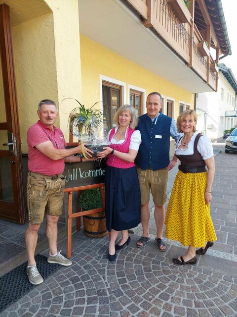 TVB-Obmann Georg Bergschober übergibt Pia und Christian Godderis mit TVB-Büroleiterin Martha Dullnig ein Willkommensgeschenk.