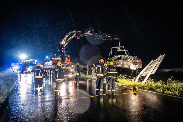 Mittels eines Kranfahrzeugs hob die Feuerwehr das Unfallfahrzeug auf die Fahrbahn zurück. | Foto: Team Fotokerschi.at/Bayer