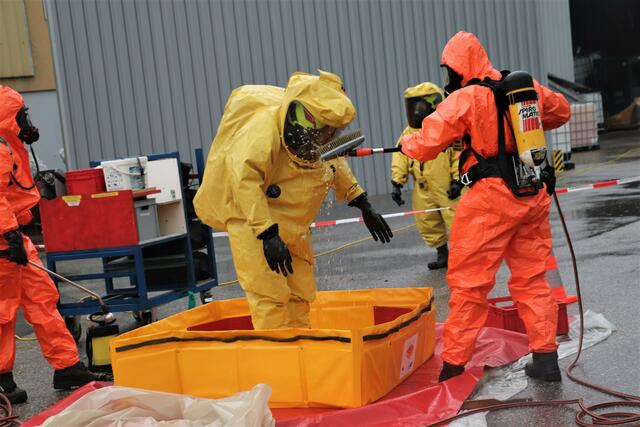 Nach dem Einsatz werden die Träger der gelben Chemikalienschutzanzüge sorgfältig mit Wasser gereinigt | Foto: Edith Ertl