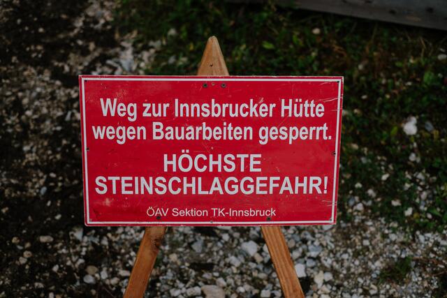 Vor jeder Arbeit stellen die Wegewarte ein Warnschild auf. | Foto: Simon Schöpf / Alpenverein