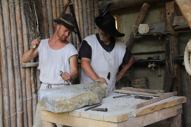Der erfahrene Steinmetz Michael Preißer zeigt einem Mitarbeiter auf der Burg, wie man im Mittelalter das Steinmaterial richtig bearbeitet hat. | Foto: Peter Pugganig
