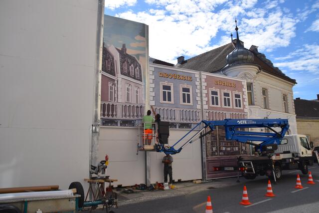 Nein, das ist keine Häuserfassade – das ist die neue "Lärmschutzwand" für die Stockerauer Festspiele: sogar die dahinter liegenden Geschäfte sind nun "noch" sichtbarer. Ein Durchgang ist, wenn gerade keine Vorstellung ist, jederzeit möglich. | Foto: Sandra Schütz