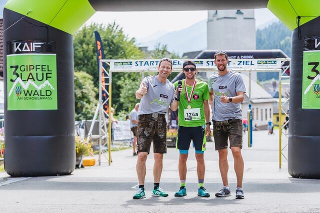 Alexander Rüdiger (l) mit Veranstalter Bürgermeister Marc Landl  (r) im Zieleinlauf des Drei-Gipfel-Laufs 2021 mit dem Sieger Lukas Vasold
 | Foto: Dominik Angerer