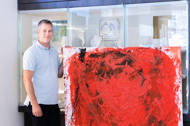 Filialleiter Günther Moik mit einem Gemälde von Petra Holasek. | Foto: Konstantinov