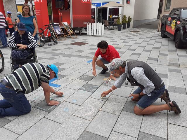 Aus der spontanen Straßenmalaktion von Andreas Schretter (re.) entstand im Nu ein buntes Bild.