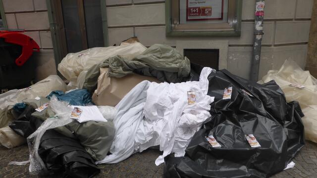 Sehr viele Tischtücher auf einem Müllhaufen, etwas versteckt hinter dem Grazer Hauptplatz...
