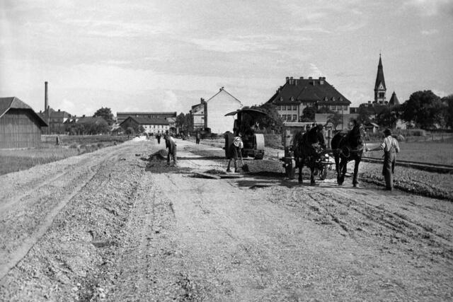 Damals 1936: Die Verlängerung der Lenaustraße
Zur Verkehrsentlastung der Wiener Straße wurde 1936 die Lenaustraße von der Höhe Anzengruberstraße bis zur Makartstraße verlängert. Für die Bauarbeiten stand neben einem Pferdefuhrwerk bereits eine dampfbetriebene Straßenwalze in Verwendung. Rechts im Bild ein Holzstadel des Bauern im Holz, im Hintergrund Werksanlagen der Lokomotivfabrik Krauss, rechts die Grillparzerschule und der Turm der Herz-Jesu-Kirche. | Foto: Archiv der Stadt Linz