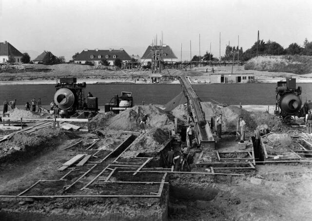 Damals 1949: Bau des Stadions
Reger Betrieb herrscht im Oktober 1949 auf der Baustelle des neuen Linzer Stadions auf der Gugl. Rund um die als Sportpatz ausersehene Fläche werden die Fundamente für die Tribünen und Kabinen errichtet. Durch Zerstörungen im Zweiten Weltkrieg gab es nach 1945 kaum benutzbare Sportplätze, geschweige denn Anlagen für größere Sportereignisse. Das neue Stadion konnte 1952 seiner Bestimmung übergeben werden. | Foto: Archiv der Stadt Linz