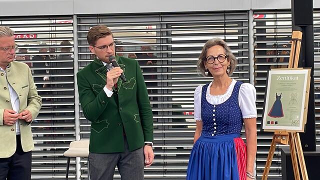 Geblümter Oberteil, gestreifter Rock, Schürze in uni und Knöpfe in Perlmutt sind die Merkmale, die Farben sind blau und rot bei der Alltagstracht. | Foto: B. Gady