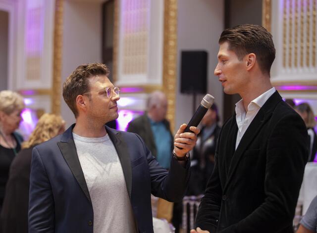 
Eingebettet in das 90-Jahre-Jubiläum des TSK Schwarz-Weiss Wien, fand in den Sophiensälen die Wiener Landesmeisterschaft der Lateintänze statt. Als Gäste wurden unter anderem die Promidamen aus dem ORF-Format Dancing Stars begrüßt.
Moderator Jakob Glanzner mit Tanzweltmeister Miha Vodicar.