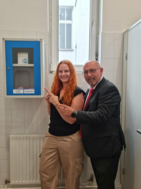 Bezirksrätin Stefanie Grötz und Bezirksvorsteher Peter Jagsch bei der Präsentation des Kastens mit den kostenlosen Menstruationsartikeln. | Foto: BV17