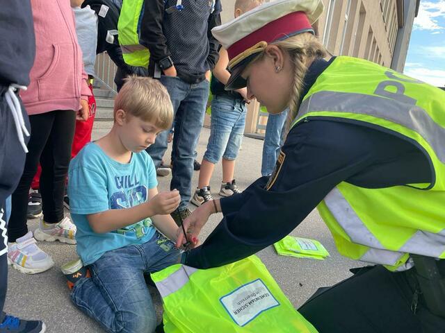 Sophie Bawaronschütz demonstriert das richtige Anbringen der Überzüge an den Schultaschen.