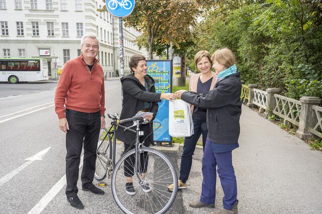 Gratulation an die einmillionste Radfahrerin, Lena Arnold, die die Zählstation am Marburger Kai passierte. Als Geschenk gab es ein Goodie-Pack der Radlobby. | Foto: Stadt Graz/Foto Fischer