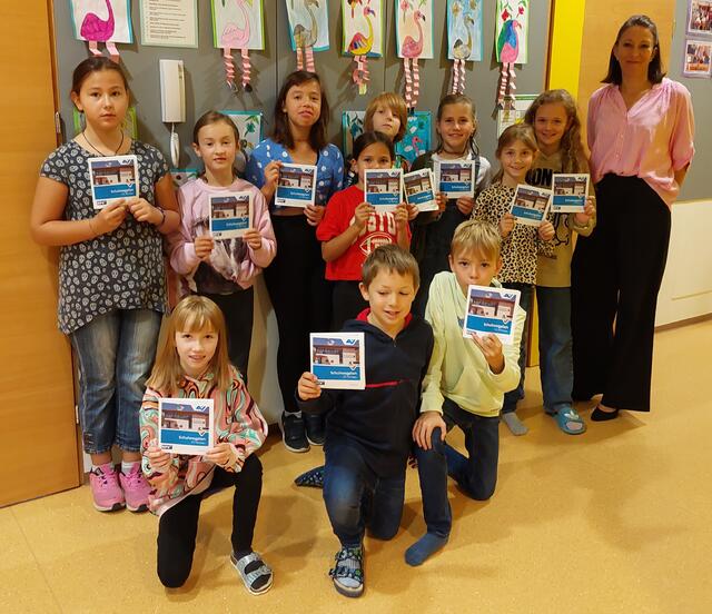 Der druckfrische Schulwegplan für Pertisau ist da. Die Kinder freuen sich zusammen mit Direktorin Sigrid Falbesoner.  | Foto: AUVA