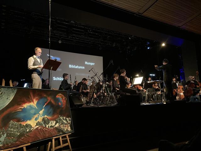 Die Bühne füllten MusikerInnen des Orchester der Akademie St. Blasius, TEMN – Tiroler Ensemble für Neue Musik und das kunst4life-Ensemble. Dirigent des 26-köpfigen Orchesters fungierte der aus Imst stammende Michael Köck, mit Mirko Schuler am Schlagwerk war ein weiterer Imster musikalisch vertreten.