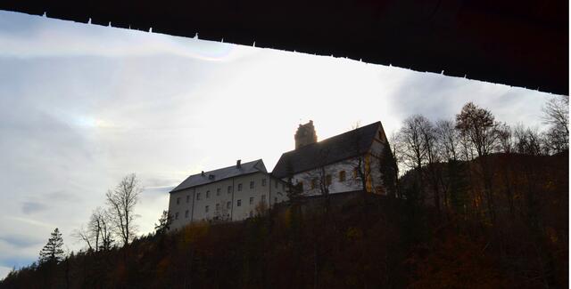 Im Gegenlicht steht das Kloster trotzig wie ein Burg auf dem Felsenkegel